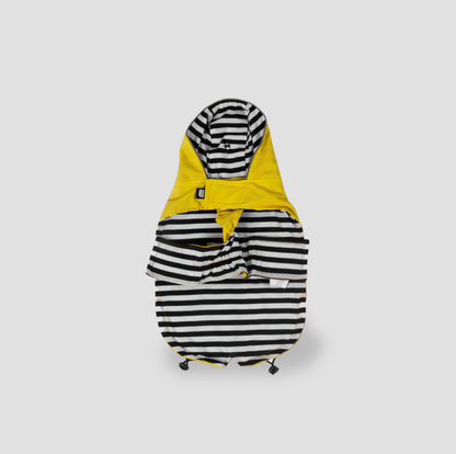 Imperméable jaune à capuche pour chien posé à plat montrant le dessous rayé noir et blanc